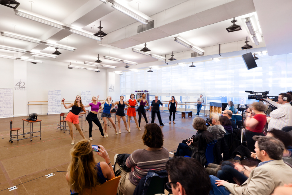 Performers working on choreography in a rehearsal studio